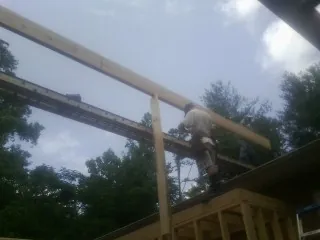 Carpenter setting a ridge beam over a new addition frame — Ice Dam Removal by Roofing Brothers in Camp Sherman
