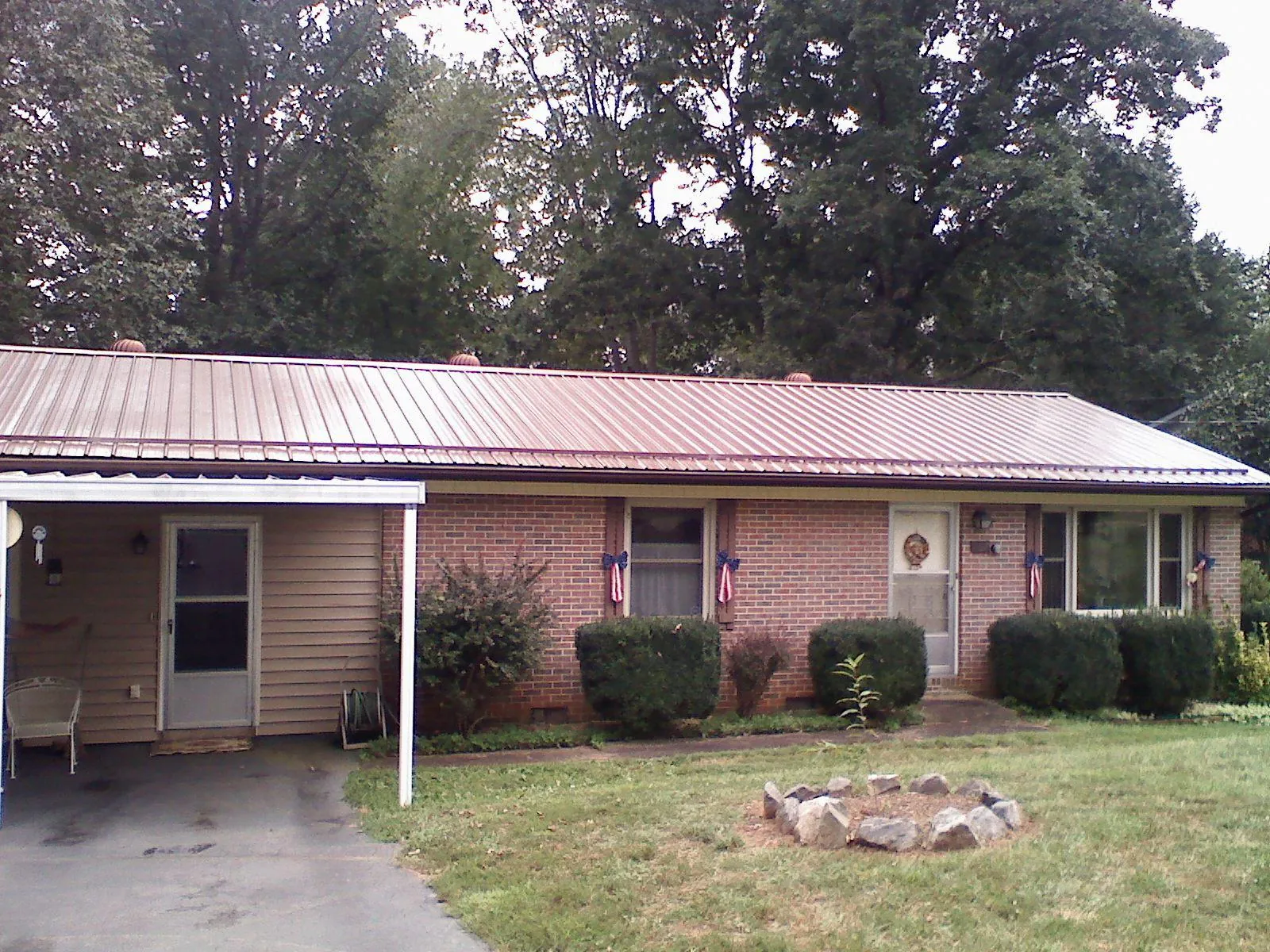 Bronze metal roof and carport on a brick ranch home — Roof Repair work by our crew in Camp Sherman