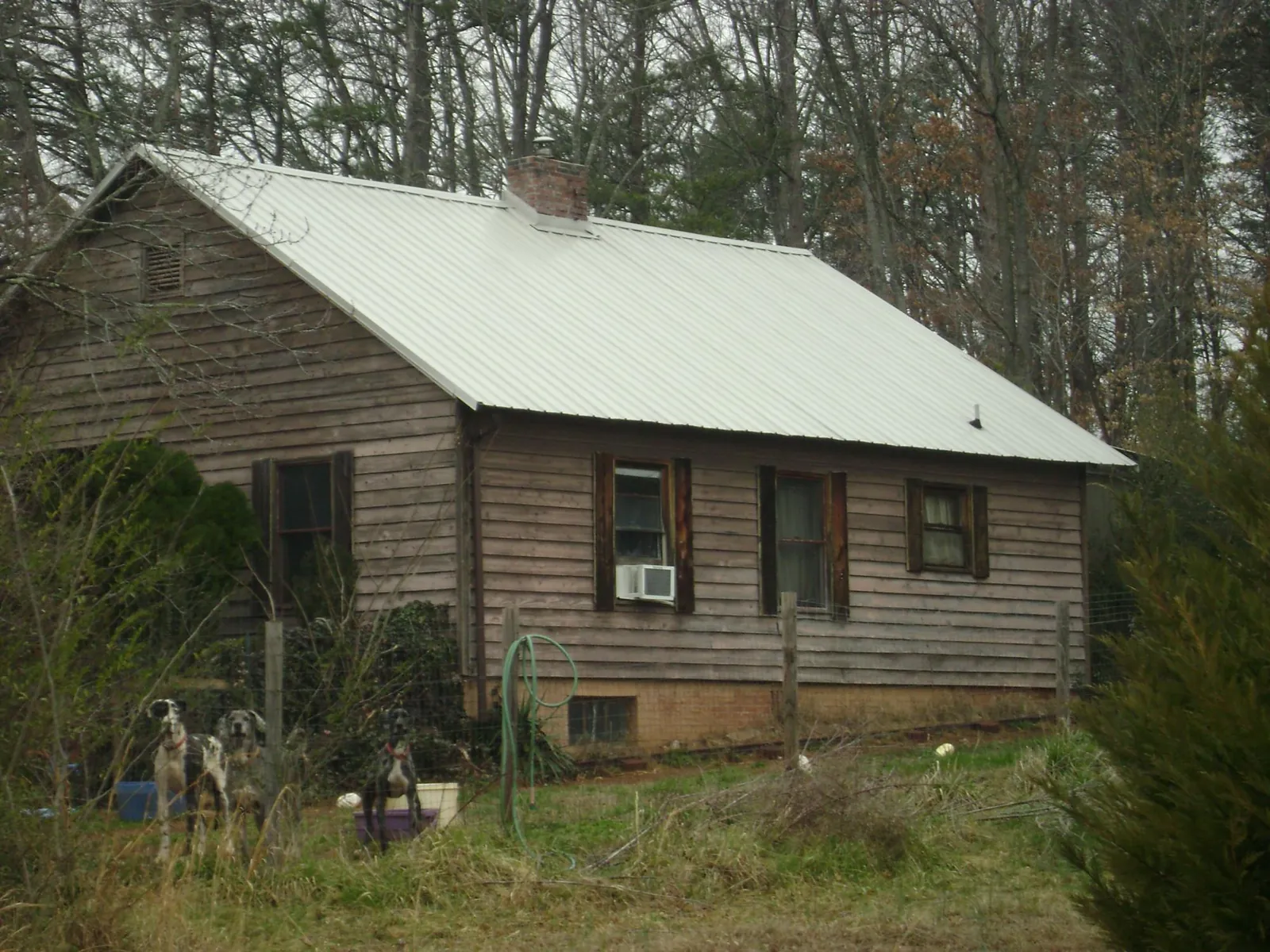 White metal roof on an old wood sided farmhouse, from a Metal Roof Installation job in Camp Sherman